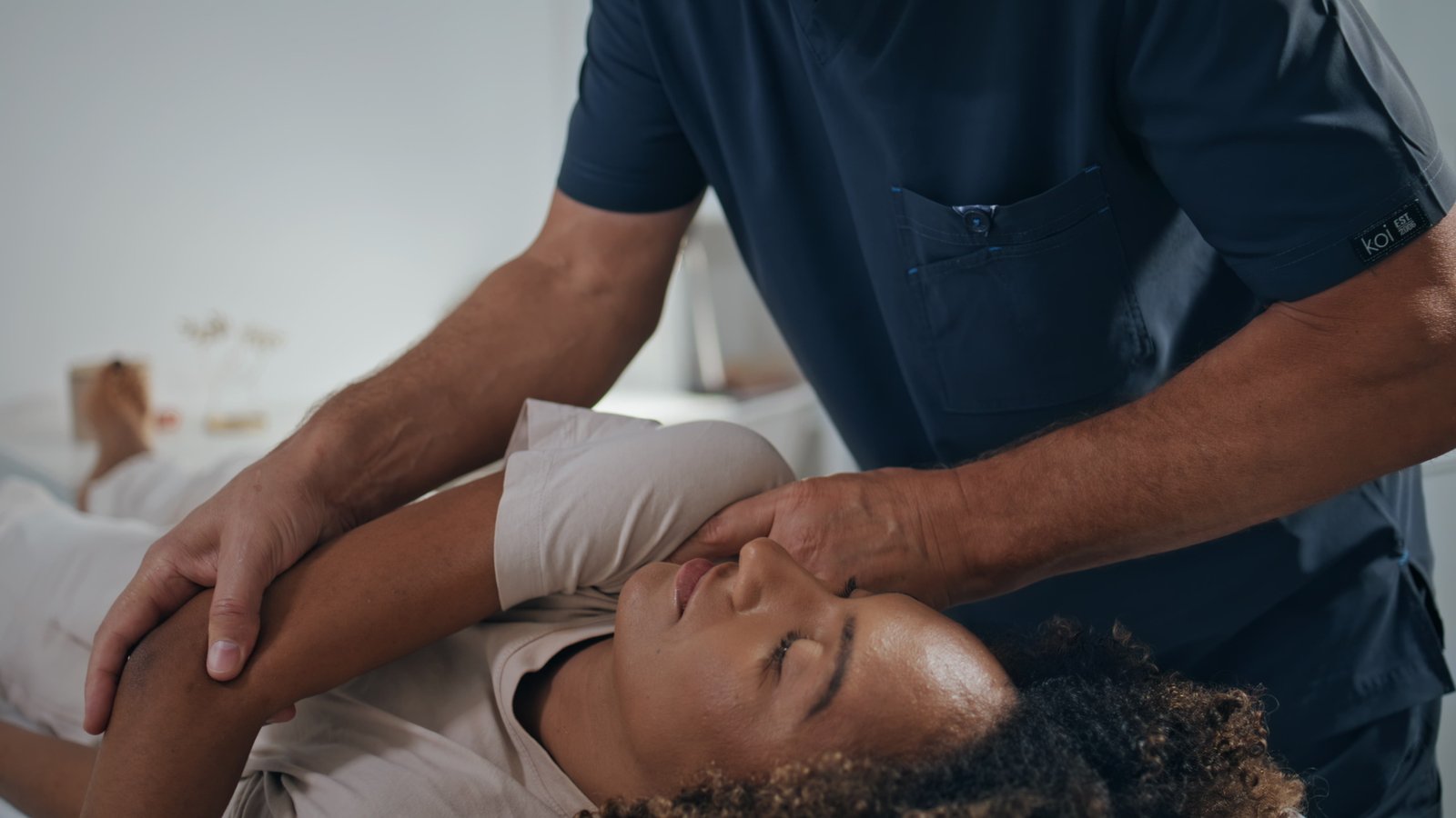 Manual chiropractor treat patient in clinic. Closeup woman visit physiotherapy Manual chiropractor treat patient in clinic. Closeup woman visit physiotherapy after trauma. Unrecognizable osteopath doing manipulation stretching back. African american girl on recovery session.