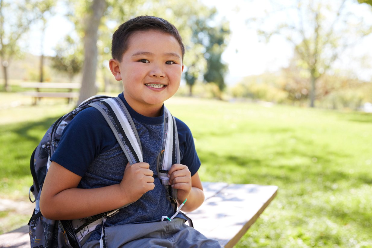 Young Asian schoolboy with backpack smiling to camera Young Asian schoolboy with backpack smiling to camera